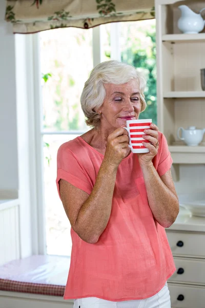 Mulher sênior tomando café na cozinha — Fotografia de Stock