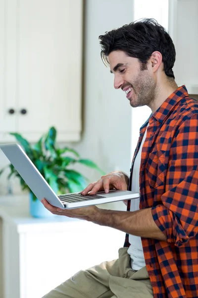 Homme souriant utilisant un ordinateur portable — Photo