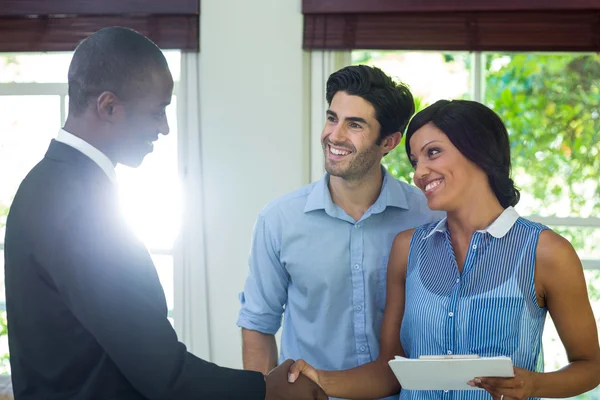 Coppia agitazione mani con agente immobiliare — Foto Stock