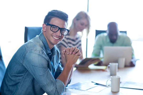 Homem sentado em sua mesa sorrindo — Fotografia de Stock