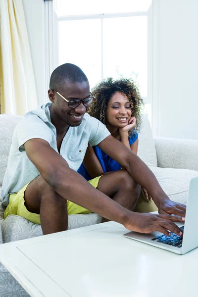 Casal no sofá e usando laptop — Fotografia de Stock