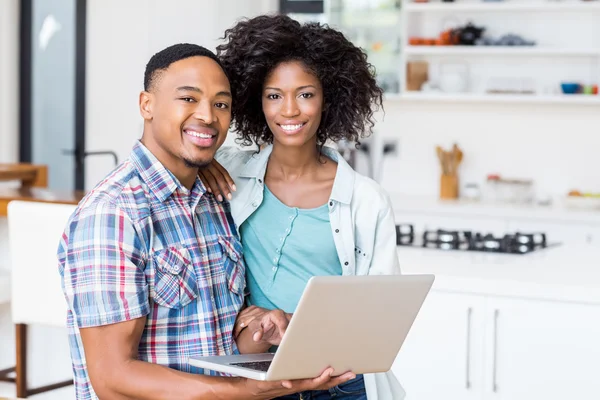 Casal usando laptop na cozinha — Fotografia de Stock