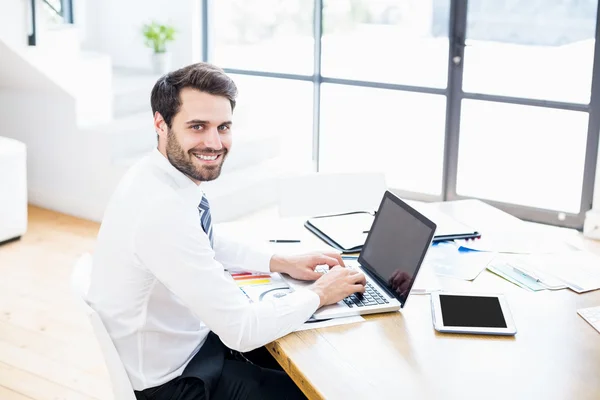 Бизнесмен использует ноутбук в офисе — стоковое фото