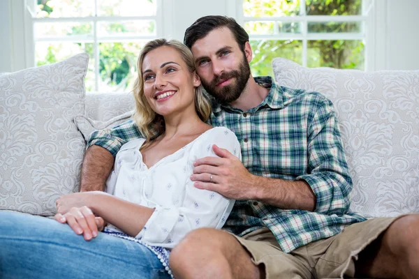 Thoughtful young couple sitting on sofa — Stock Photo, Image