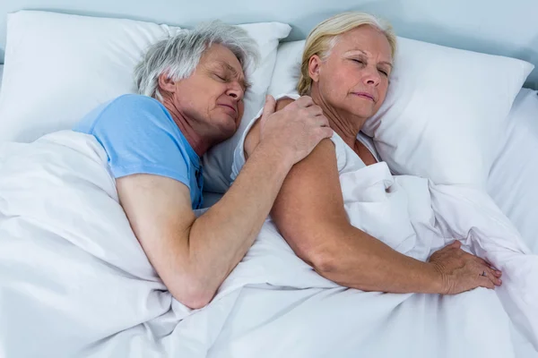 Seniorenpaar schläft auf Bett — Stockfoto