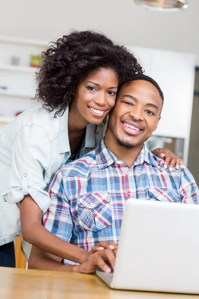 Casal usando laptop na cozinha — Fotografia de Stock