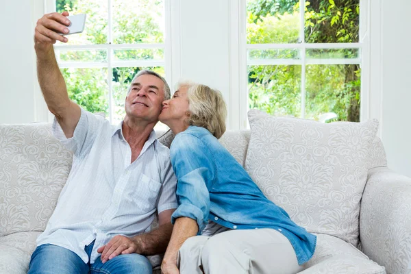 Donna baciare mentre l'uomo prende selfie — Foto Stock