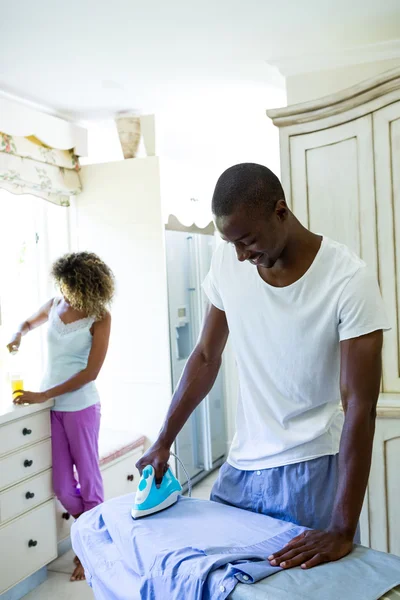 Hombre planchando una camisa en la cocina —  Fotos de Stock