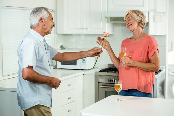 Hombre mayor dando rosa a la mujer — Foto de Stock