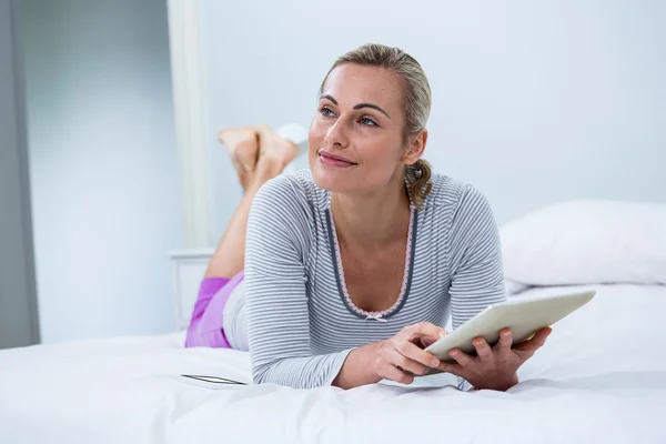 Vrouw met digitale tablet op bed — Stockfoto