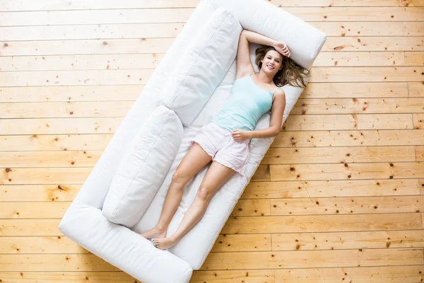 Jonge vrouw ontspannen op de bank — Stockfoto