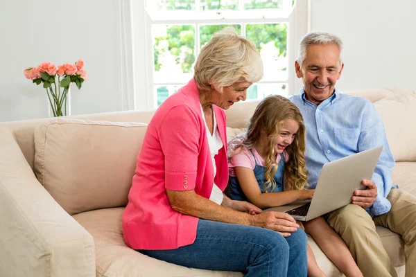 Großeltern und Mädchen mit Laptop — Stockfoto