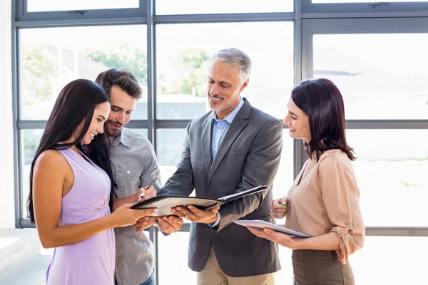 Vermittler übergibt Vertrag an Paar — Stockfoto