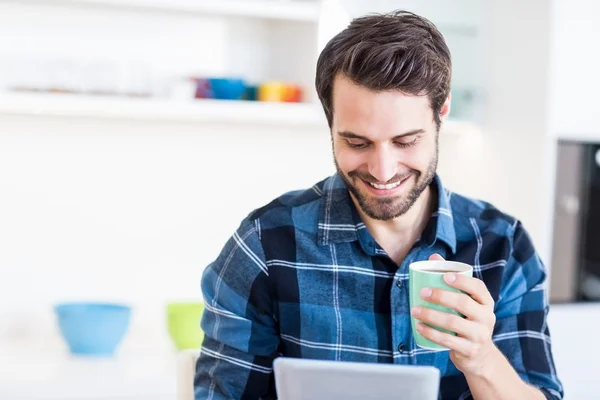 Man som tar tabletter samtidigt som man dricker kaffe — Stockfoto