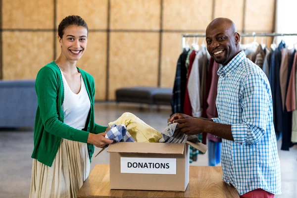 Collega's sorteren van de kleding van donatie box — Stockfoto