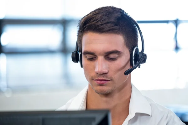 Ο άνθρωπος που εργάζεται στον υπολογιστή με ακουστικά — Φωτογραφία Αρχείου
