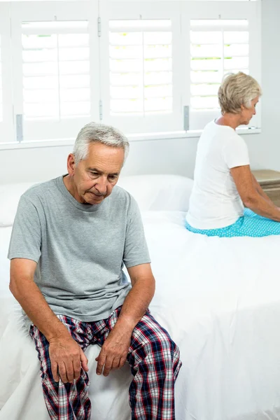 Triste uomo sul letto con donna — Foto Stock