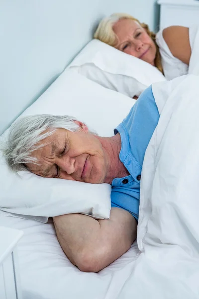 Starší pár, položenou na posteli — Stock fotografie