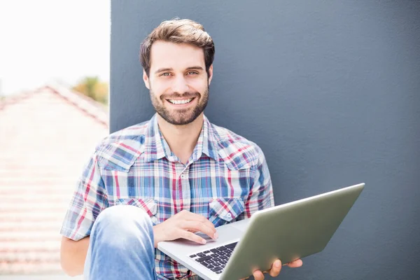 Uomo seduto sulla terrazza utilizzando il computer portatile — Foto Stock