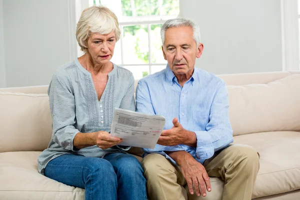 Triste pareja de ancianos leyendo documento —  Fotos de Stock
