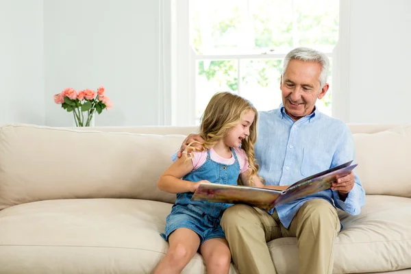 Κορίτσι και ο παππούς με το εικονογραφημένο βιβλίο — Φωτογραφία Αρχείου