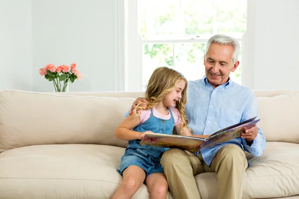 Mädchen und Opa mit Bilderbuch — Stockfoto