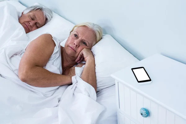 Gondolkodó idősebb nő pihentető ágyon — Stock Fotó