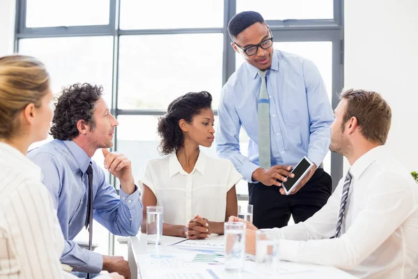 Affärskollegor diskuterar över en tablett — Stockfoto