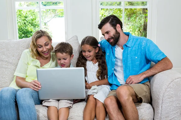 Niños con padres usando laptop — Foto de Stock