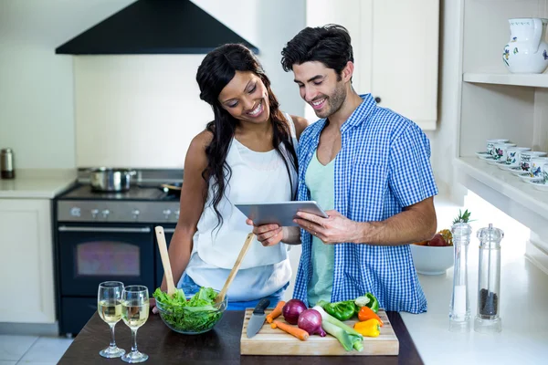 Пара с помощью планшета на кухне — стоковое фото