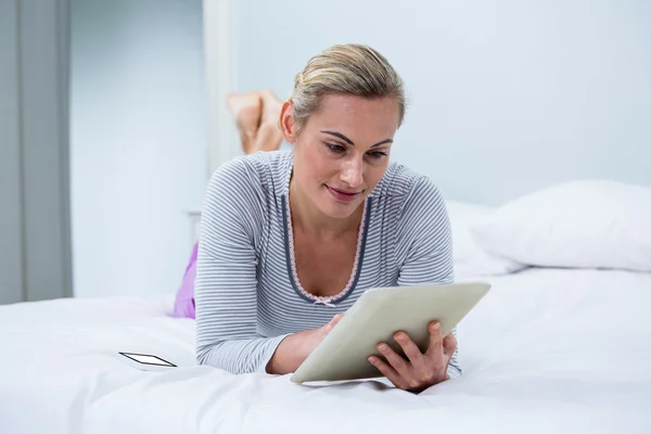 Γυναίκα χρησιμοποιώντας ψηφιακή δισκίο σε κρεβάτι — Φωτογραφία Αρχείου
