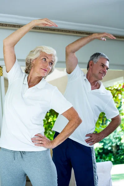Senior couple bending while doing aerobics — Stock Photo, Image