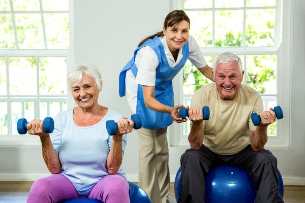 Nurse assisting senior man and woman — Stock Photo, Image