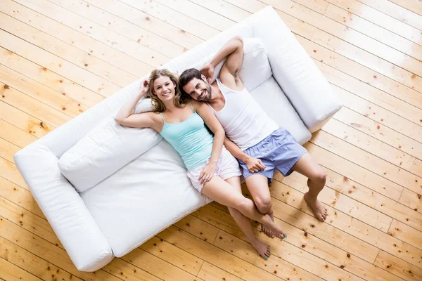 Jeune couple relaxant sur canapé — Photo