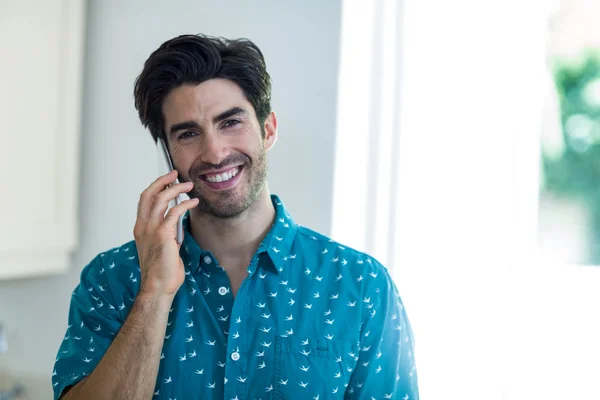 Hombre hablando por teléfono en la cocina — Foto de Stock