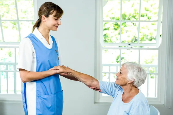 Медсестра помогает активному старшему — стоковое фото