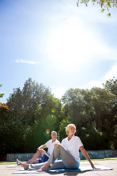 Couple aîné faisant de l'exercice au bord de la piscine — Photo