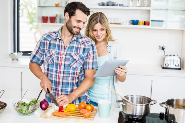 Pareja picando vegetales usando tableta —  Fotos de Stock