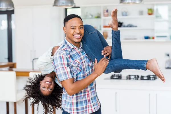 Man opheffing van zijn vrouw in de keuken — Stockfoto