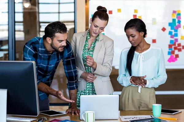 Uomo e donne discutono utilizzando il computer portatile — Foto Stock