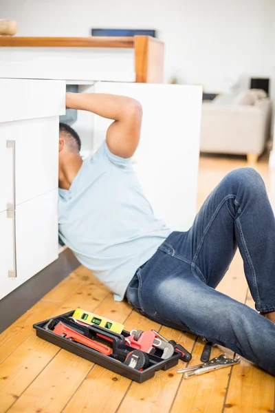 Homem reparando uma pia da cozinha — Fotografia de Stock