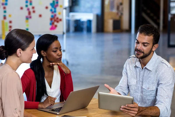 Team av kollegor diskuterar vid skrivbord — Stockfoto