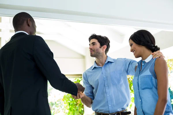 Real estate agent giving keys to couple — Stock Photo, Image