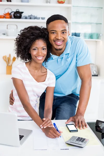 Couple using laptop while calculating bills — Stock Photo, Image