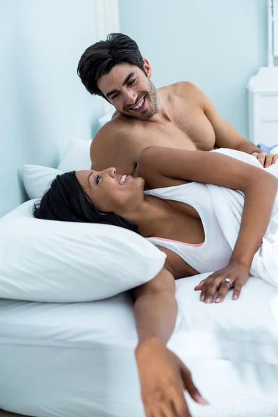 Casal abraçando enquanto deitado na cama — Fotografia de Stock