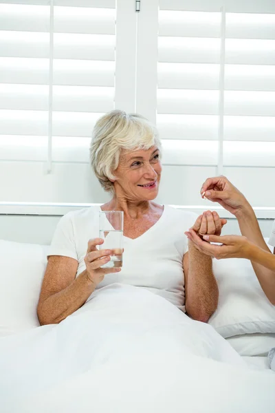 Arzt gibt Seniorin Medikamente — Stockfoto