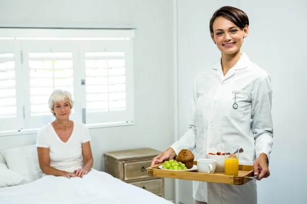 Betreuerin hält Frühstückstablett — Stockfoto