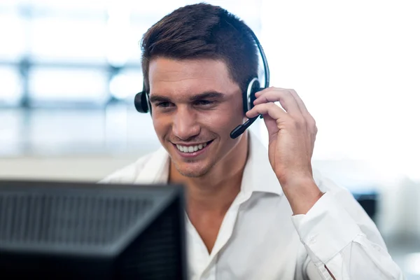 Uomo che lavora al computer con auricolare — Foto Stock