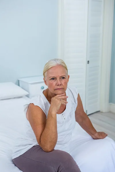 Seniorin mit Hand am Kinn verärgert — Stockfoto