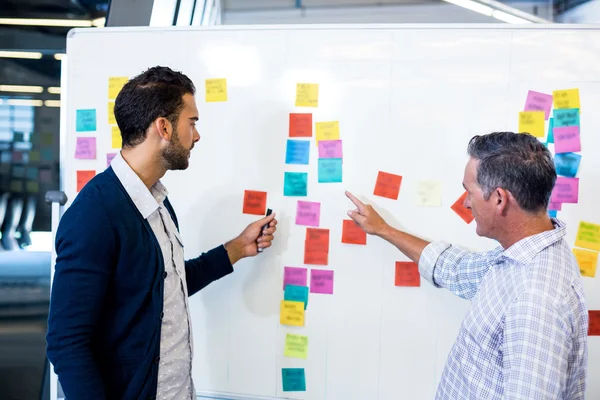 Colleagues reading sticky notes — Stock Photo, Image